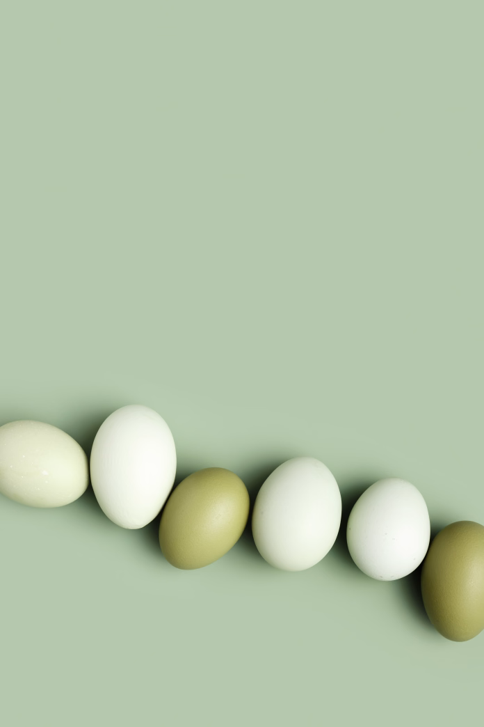 Top view natural easter Eggs green color with shadows on green background, minimal trend food pattern from organic Chicken egg with color gradient eggshells, Easter food celebration concept, copyspace
