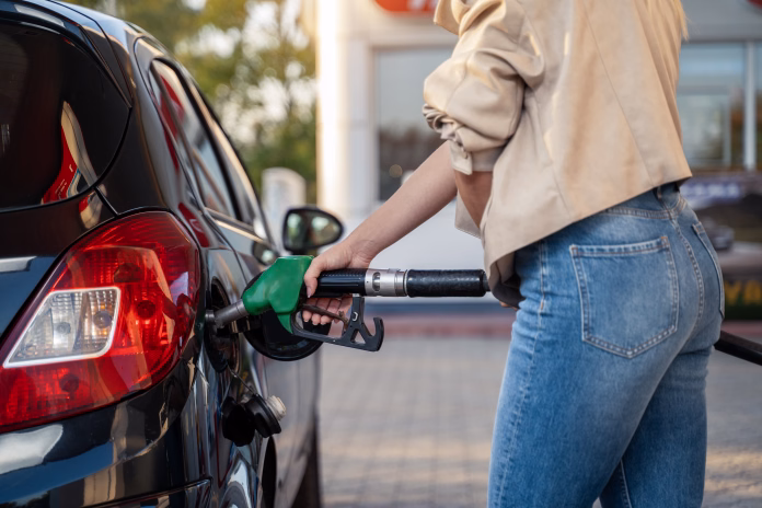 Unrecognizable woman fills up car tank on the gas station