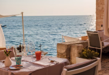 Slovenci vse manj zainteresirani za počitnice na Hrvaškem; to so tri države, v katere vse bolj radi potujejo A charming table set for two invites diners to enjoy a sunset meal overlooking the shimmering waters of the Adriatic Sea in Rovinj, Croatia. The atmosphere is warm and serene.
