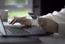 Tisoče Slovencev ostaja brez priljubljene funkcije za plačevanje računov: treba bo spremeniti navade Female hands holding credit card and using laptop. Online shopping