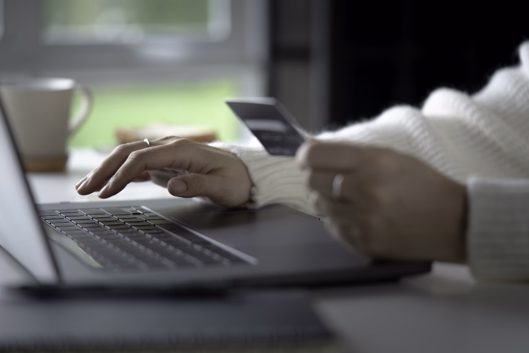 Female hands holding credit card and using laptop. Online shopping