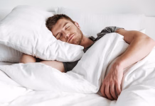 Zakaj je vzglavnik pomembnejši, kot si mislite? Handsome young man sleeping in bed at home