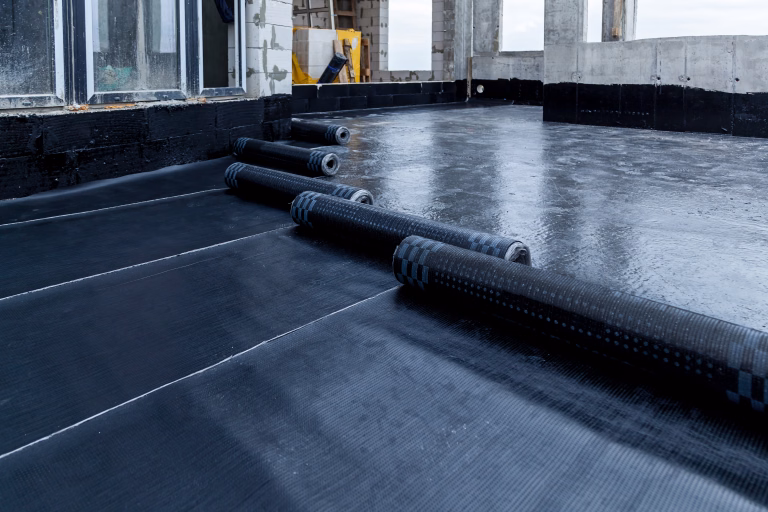 Laying and installation of roofing, bituminous waterproofing of an apartment building. Rolled roofing waterproofing of concrete slabs of stylobate. Heating and melting of bituminous roofing material.