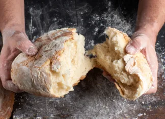 To boste od zdaj naprej vsakič preverili! Tako boste vedeli, ali vam prodajajo »zamrznjen« ali svež kruh. male hands breaking open baked bread in half over black wooden table