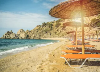 Kepica sladoleda je tukaj okoli 1,40 evra, pivo 2 evra, obrok pa okoli 10 evrov … Straw beach umbrella with sea ocean beach background travel concept tourism concept exotic beach
