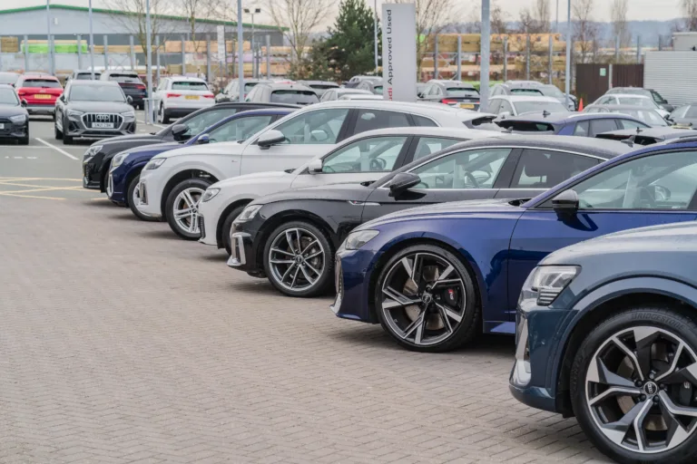 Trentham, Stoke-on-Trent, England, February 10th 2023. A row of Audis parked at a dealership lot, transport and retail editorial illustration.