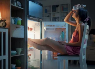 Slovenijo je zajel vročinski val, večina pa stanovanja hladi povsem narobe! S tem temperaturo le še zvišujejo … Ženska trpi zaradi poletne vročine; počiva z nogami v hladilniku in v roki drži steklenico vode.