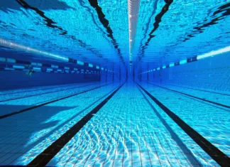 Cene kopališč v Ljubljani 2026: Kje se najbolj splača kopati in komu se izplača sezonska vstopnica? 50 meter sports pool. Swimming pool underwater background.