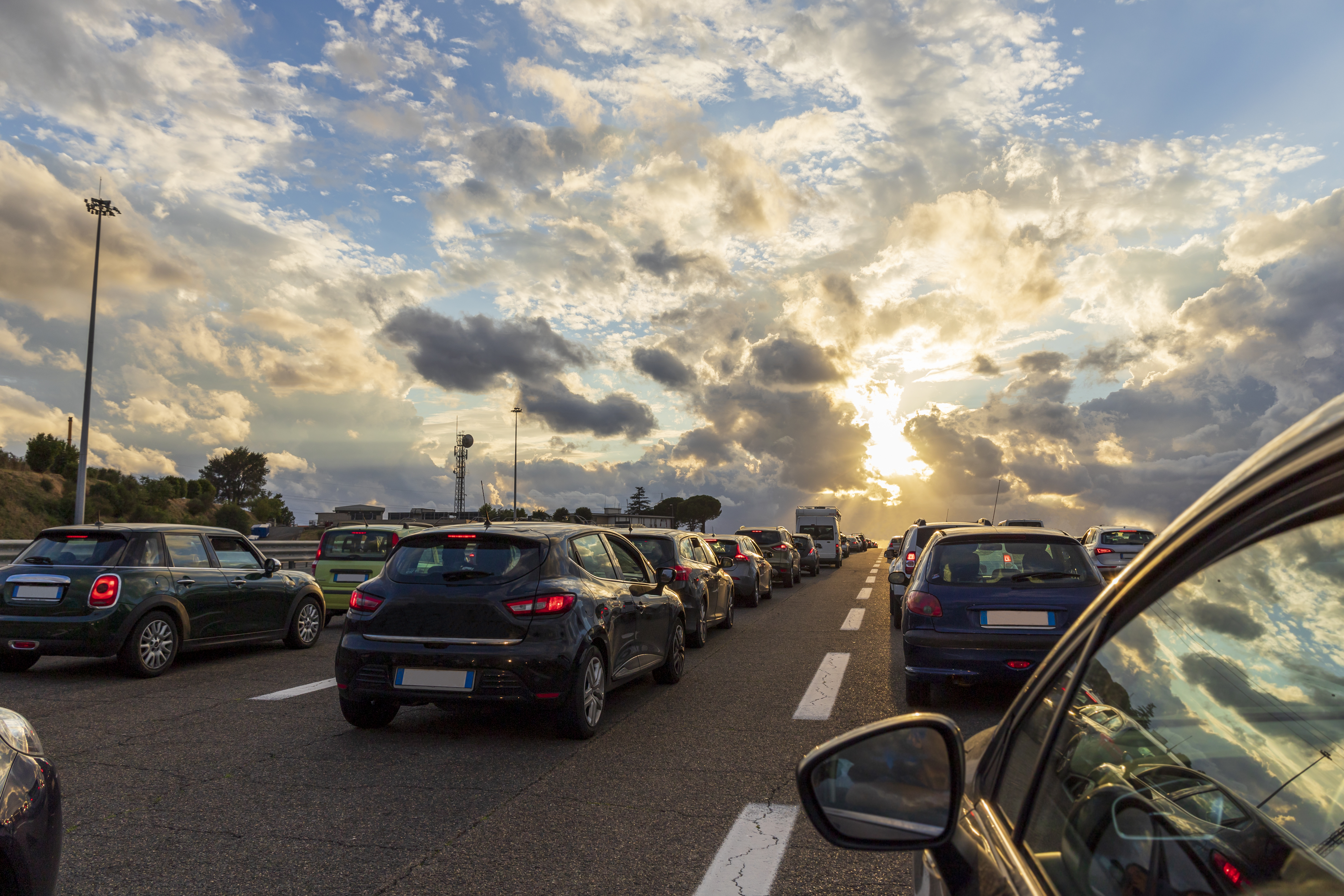 Cars lined up on an Italian highway at sunset. Highway traffic jam.