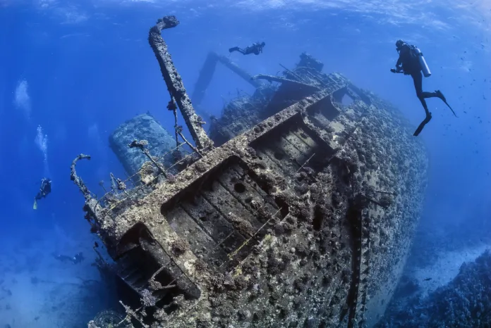 divers-exploring-the-outside-of-a-shipwreck-stockpack-istock Divers exploring the outside of a shipwreck