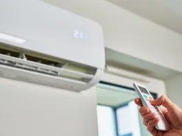 Hand adjusting temperature on air conditioner with remote control, Working air conditioner for comfort temperature in home at hot summer