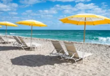 Dopust za 1.000 €? Na koncu vas lahko stane skoraj 2.000 € Luxury beach chairs and yellow umbrellas on white sand at the sea in Fort Lauderdale, Florida. No people.