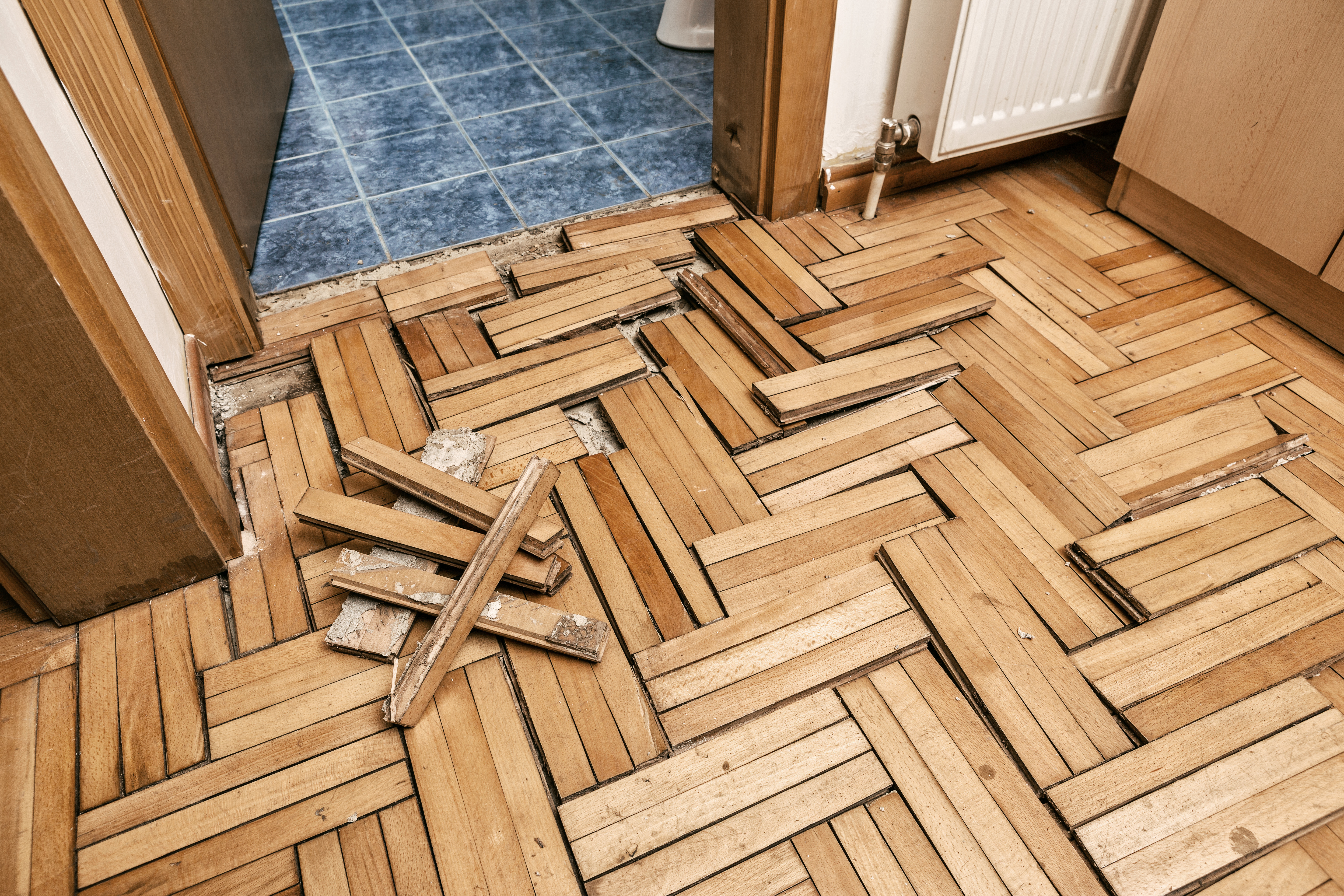 Ruined flooring from moisture and water from bathroom