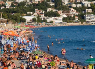 Kava 1,5 evra, zajtrk 4, apartma 20 evrov: to je najcenejše letovišče na Jadranu SUTOMORE, MONTENEGRO - SEPTEMBER 07, 2015: Unidentified people are relaxing on the beach. Montenegro is one of the most attractive destinations for tourists