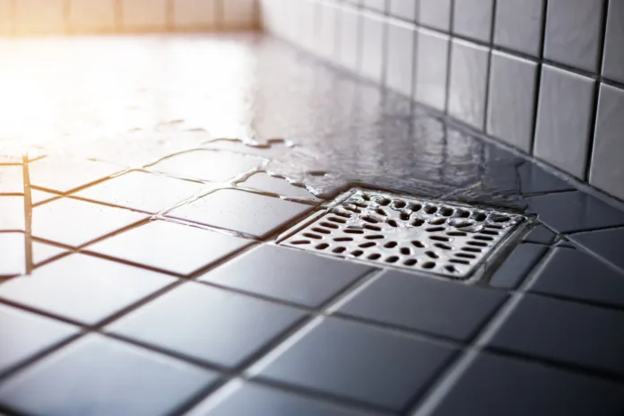 water-flowing-to-square-shower-drain-hygiene-and-clean-on-tiled-floor-of-modern-enclosure-in-bathroom-stockpack-istock Water flowing to square shower drain hygiene and clean on tiled floor of modern enclosure in bathroom.