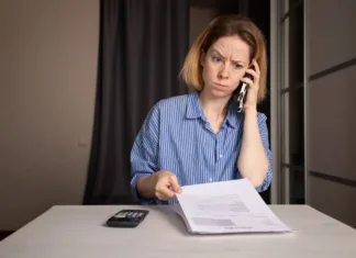 Je račun za vodo poleti višji, kot pričakujete? Preverite teh 5 pogostih razlogov Woman Discussing Utility Bills Over Phone, confused customer reviewing invoice, discussing high energy cost and finance trouble