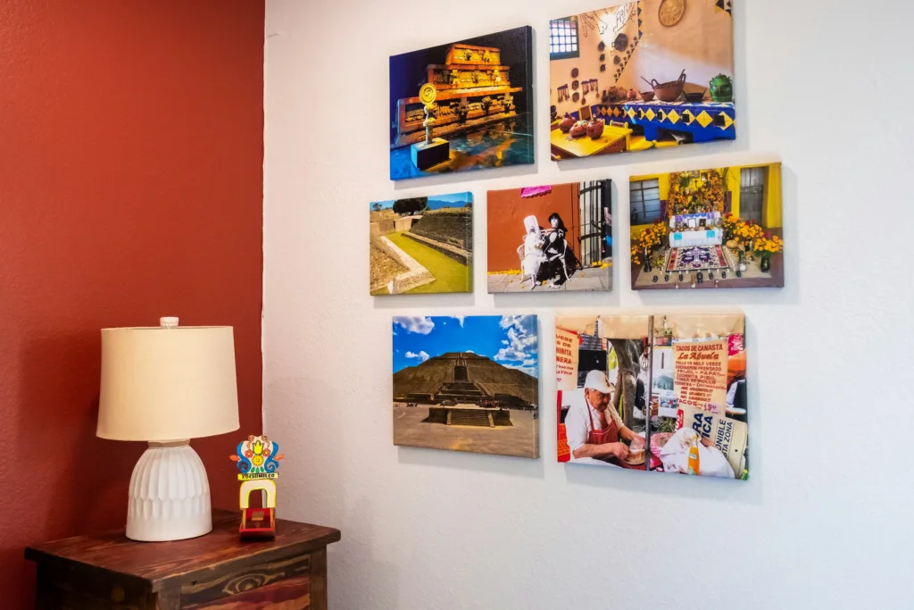 A stylish room with a captivating image wall showcasing diverse artwork. The corner table lamp casts a warm glow, adding a cozy ambiance to the space.