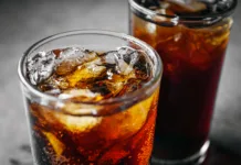 Kupujete Coca Colo, Fanto in Schweppes? Uf, ta navada vas na leto lahko stane več kot … Cola soft drink with ice cubes, Close up of soda fizzy drink in Cold glass on gray background
