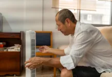 Španci ne prižigajo klimatske naprave, vsak dan ob 11. uri naredijo to: »Deluje odlično, kot hladilnik« Relaxed male feeling relief from portable air conditioner cooling in warm home interior during sweltering summer afternoon