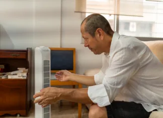 Španci ne prižigajo klimatske naprave, vsak dan ob 11. uri naredijo to: »Deluje odlično, kot hladilnik« Relaxed male feeling relief from portable air conditioner cooling in warm home interior during sweltering summer afternoon