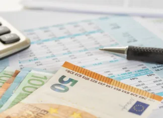 Ni hladilnik, tudi pečica ne: ta naprava porabi največ elektrike v vašem domu in zvišuje znesek na računu Some euro bills on documents with a calculator