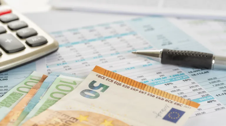 Some euro bills on documents with a calculator
