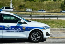 Greste na Hrvaško? Pozor, kazni gredo v nebo, preverite, kdo bo prvi na udaru Zagreb, Croatia - August 25, 2025: Croatian police vehicle parked beside a highway with cars passing on a clear day in Croatia.