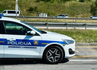 Greste na Hrvaško? Pozor, kazni gredo v nebo, preverite, kdo bo prvi na udaru Zagreb, Croatia - August 25, 2025: Croatian police vehicle parked beside a highway with cars passing on a clear day in Croatia.