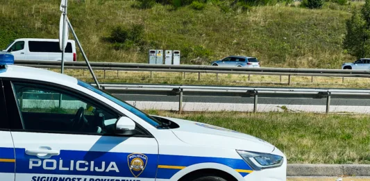 Zagreb, Croatia - August 25, 2025: Croatian police vehicle parked beside a highway with cars passing on a clear day in Croatia.
