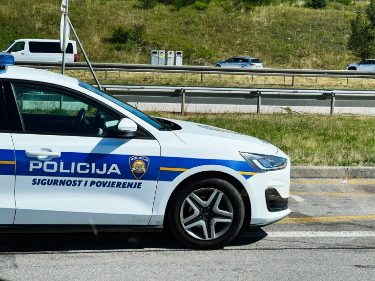 Zagreb, Croatia - August 25, 2025: Croatian police vehicle parked beside a highway with cars passing on a clear day in Croatia.