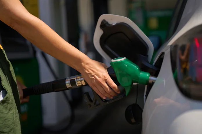 close-up-of-a-womans-hand-holding-a-gas-pump-refueling-her-car-at-a-gas-station-stockpack-istock Close up of a woman's hand holding a gas pump, refueling her car at a gas station
