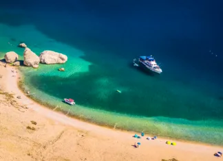 Razglasili najbolj skrite plaže v Evropi: prvo mesto osvojil hrvaški biser Drone image of Beritnica beach on Pag island showing unique rocky formations, clear turquoise sea, barren karst terrain and a dramatic Adriatic coastal landscape in bright sunlight