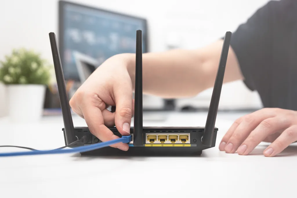 Man connects the internet cable to the router's socket. Fast and wireless internet concept