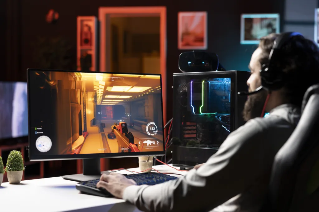 Pro gamer wearing headphones competing in intense online multiplayer videogame, shooting enemies with futuristic gun. Man using gaming computer and headset mic to play internet game with friends