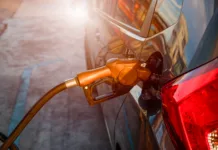 Nemški način točenja goriva vam bo prihranil denar: to je najugodnejši del dneva za obisk bencinske Pumping gas at gas pump. Closeup of man pumping gasoline fuel in car at gas station.