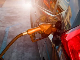Nemški način točenja goriva vam bo prihranil denar: to je najugodnejši del dneva za obisk bencinske Pumping gas at gas pump. Closeup of man pumping gasoline fuel in car at gas station.