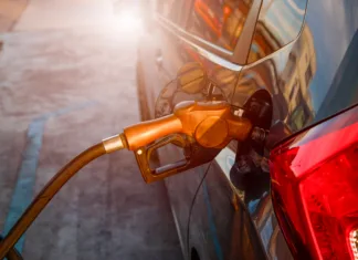 Nemški način točenja goriva vam bo prihranil denar: to je najugodnejši del dneva za obisk bencinske Pumping gas at gas pump. Closeup of man pumping gasoline fuel in car at gas station.