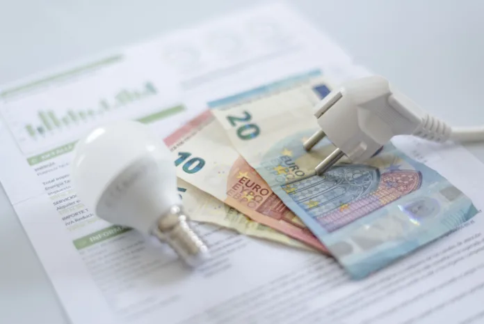 a-white-electric-cap-a-light-bulb-and-euro-banknotes-on-an-electric-bill-increase-in-the-cost-of-electricity-for-residential-customers-and-business-users-payment-of-electricity-bills-increasing-the-co-stockpack-istock a white electric cap, a light bulb and euro banknotes on an electric bill. Increase in the cost of electricity for residential customers and business users. Payment of electricity bills. Increasing the concept of electricity prices.