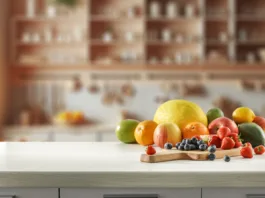 1 stvar privablja denar v dom kot nora: Kitajci jo imajo vedno na mizi, najdete pa jo na vsaki tržnici Blurred kitchen interior and fresh fruit on wooden cutting board on white countertop and space for food and drink and products and objects. Natural daily light coming through the window.