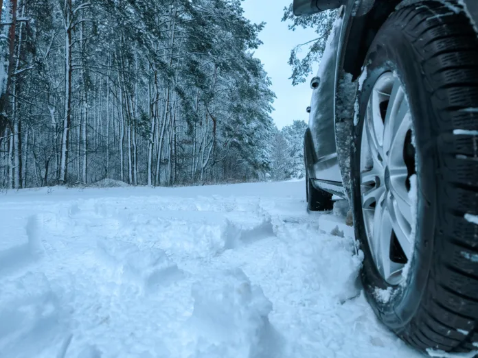 Car tires in the snow close-up. Winter tires as the basis of travel safety in the winter season. High quality photo