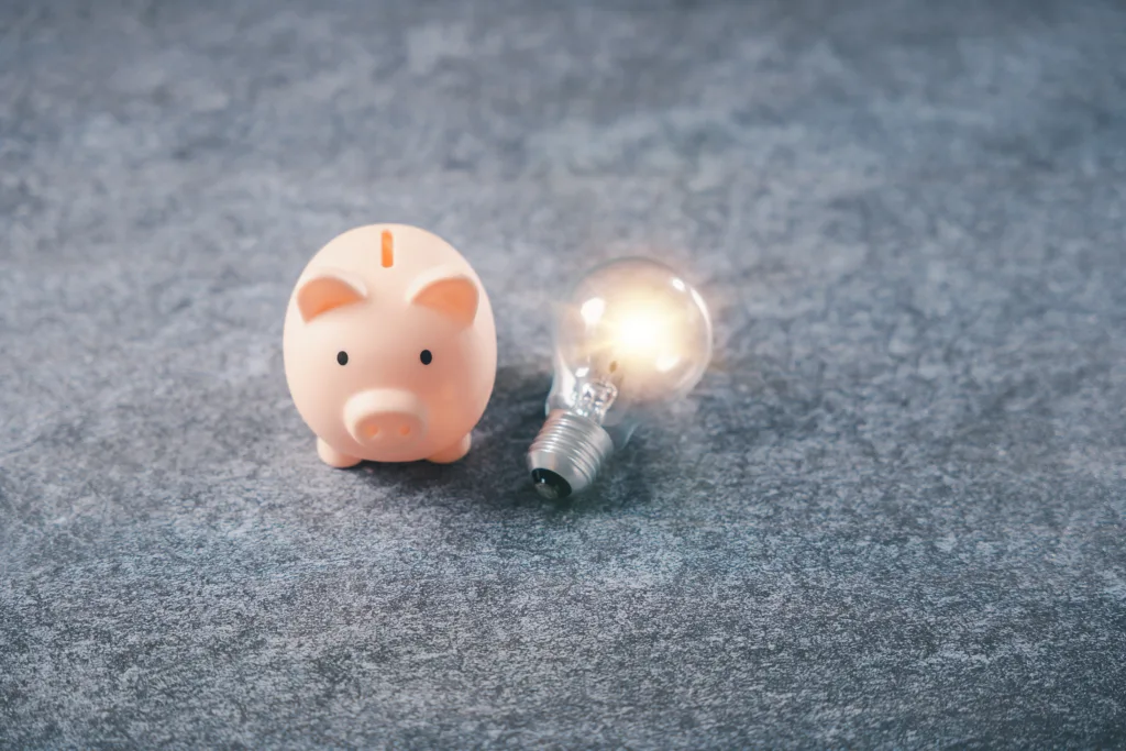Creative fintech ideas, light bulb disruption, and infrastructure beside pink piggy bank symbolize financial innovation and digital transformation for wealth management planning.