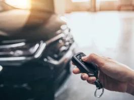 Hand presses unlock on the car remote control.