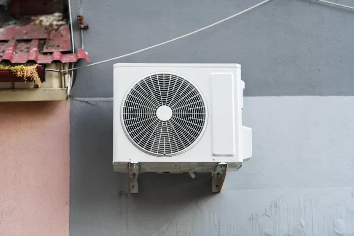 The outdoor unit of a domestic split air conditioning system installed on the wall of a building.