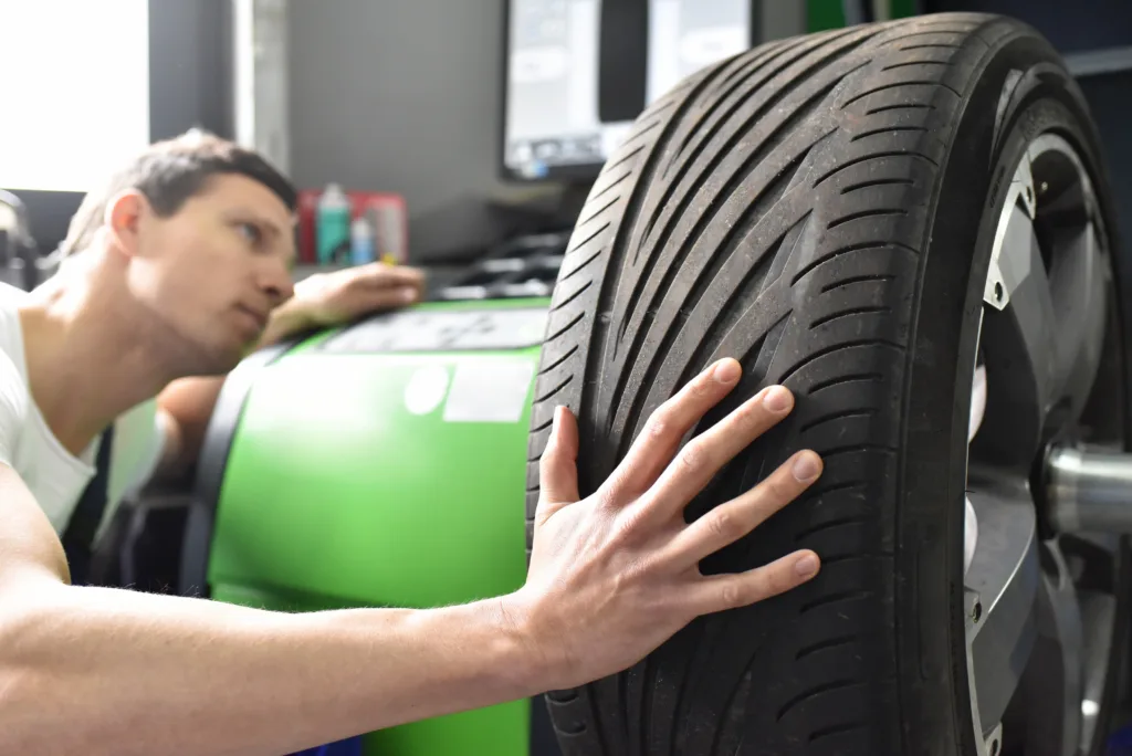 tyre change in a garage - assembler balancing a tyre on the machine
