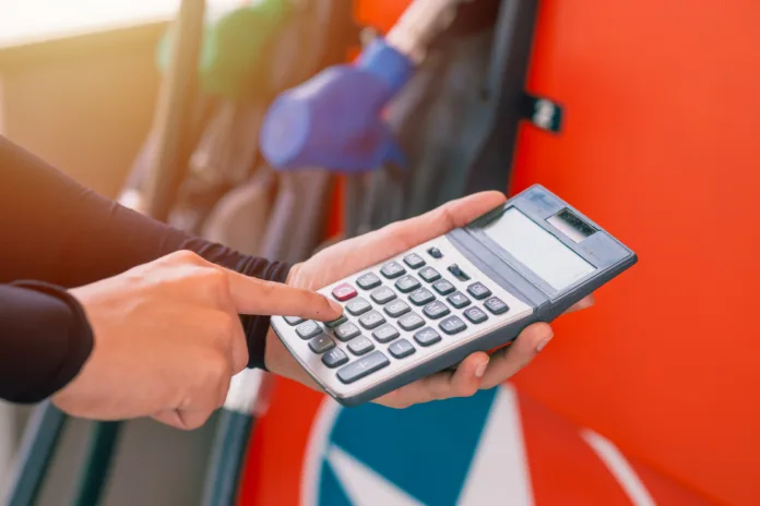 Closeup gas station staff worker hand calculator calculate price car fuel cost low or high price bill, Petroleum business