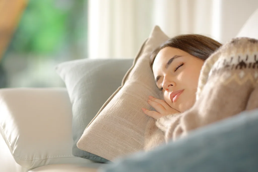 Woman sleeping lying on a couch at home