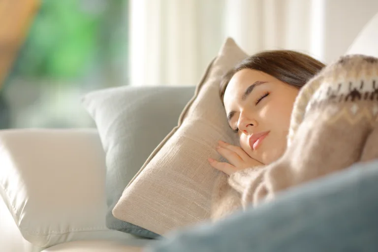 Woman sleeping lying on a couch at home